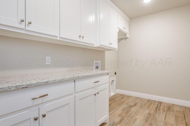 clothes washing area with cabinets, washer hookup, light wood-type flooring, and electric dryer hookup