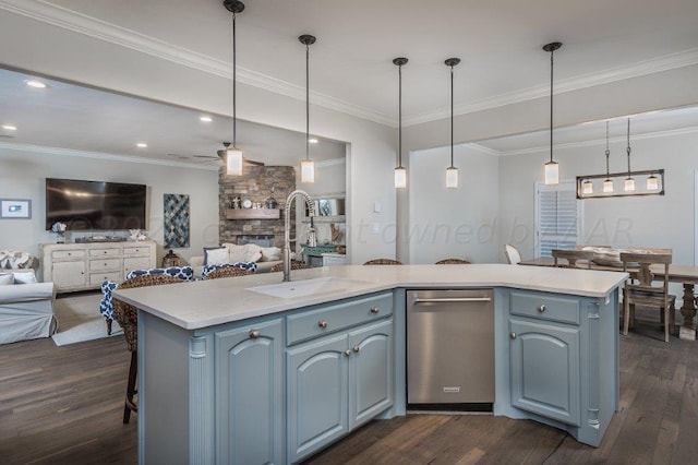 kitchen featuring decorative light fixtures, dark hardwood / wood-style floors, sink, blue cabinets, and a kitchen island with sink