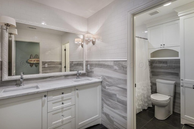 bathroom featuring toilet, tile patterned floors, tile walls, vanity, and a shower with shower curtain