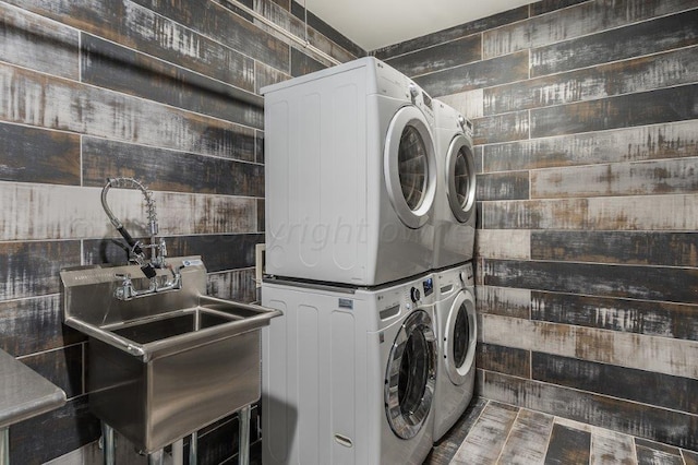 laundry area with sink and stacked washer / drying machine