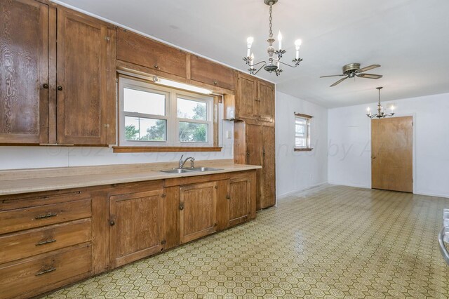 kitchen featuring ceiling fan with notable chandelier, sink, and decorative light fixtures