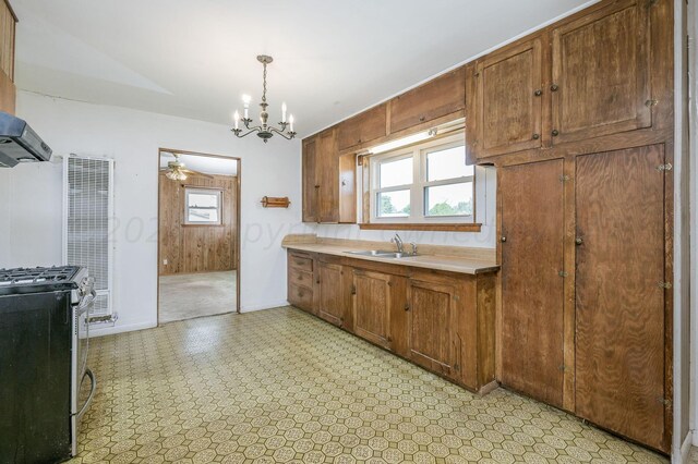 kitchen with hanging light fixtures, an inviting chandelier, stainless steel gas range oven, and plenty of natural light