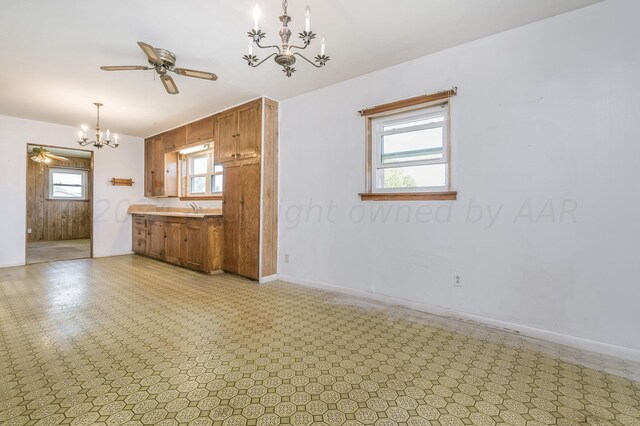 kitchen featuring sink, decorative light fixtures, and ceiling fan with notable chandelier