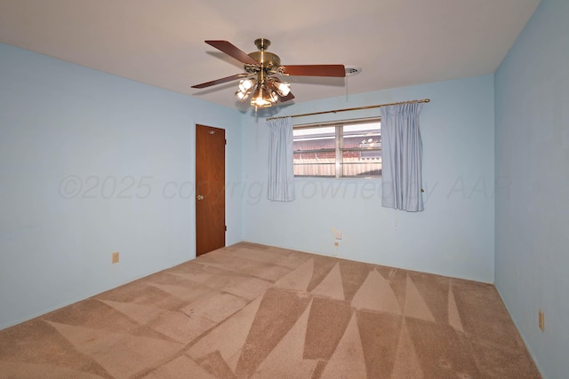 carpeted empty room with a ceiling fan