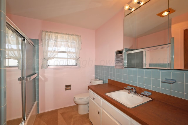 bathroom featuring a shower with door, toilet, vanity, and backsplash