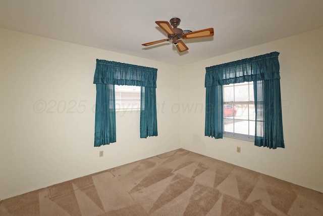 empty room with carpet floors and a ceiling fan