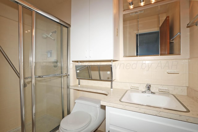 full bath with a stall shower, vanity, toilet, and tasteful backsplash