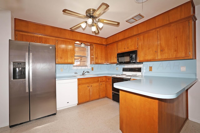 kitchen featuring stainless steel fridge, electric stove, black microwave, a peninsula, and brown cabinetry