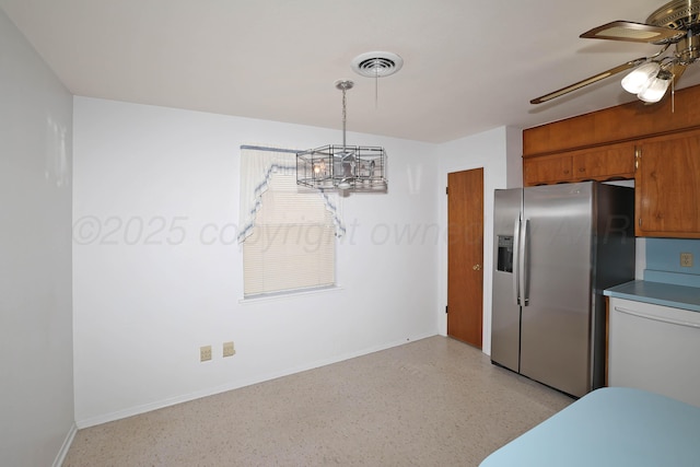 kitchen featuring stainless steel refrigerator with ice dispenser, a ceiling fan, baseboards, a chandelier, and brown cabinetry