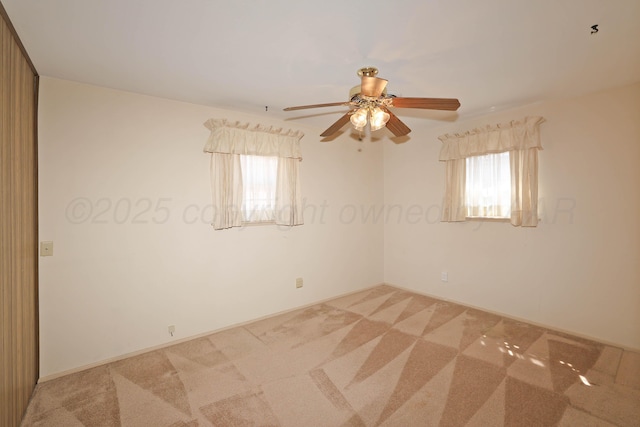 empty room featuring light colored carpet and ceiling fan