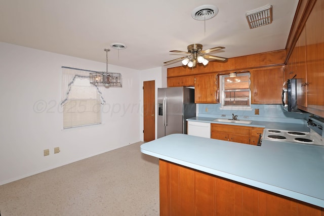 kitchen with white appliances, brown cabinets, a sink, a peninsula, and a ceiling fan