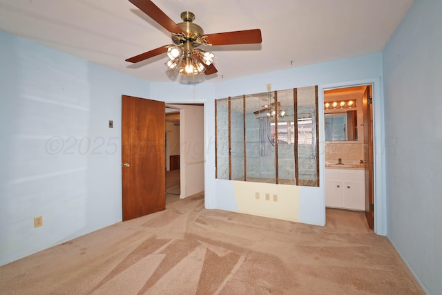 unfurnished bedroom with light colored carpet, a sink, ensuite bath, and ceiling fan