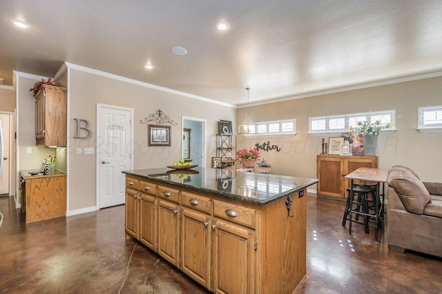 kitchen featuring an island with sink, dark stone counters, decorative light fixtures, and ornamental molding