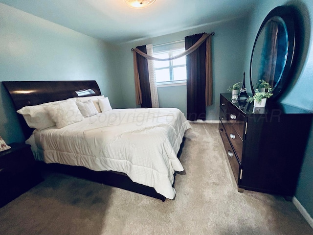 bedroom with baseboards and light carpet