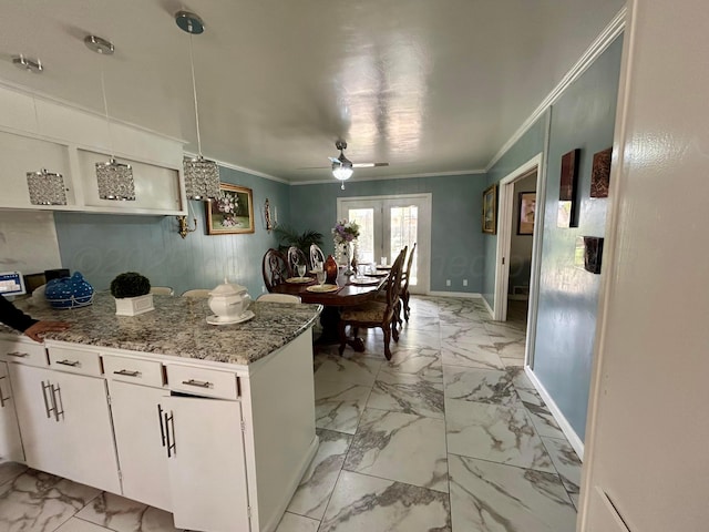 kitchen featuring white cabinetry, ceiling fan, ornamental molding, and marble finish floor