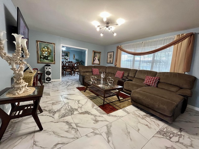 living area featuring baseboards, a chandelier, and marble finish floor