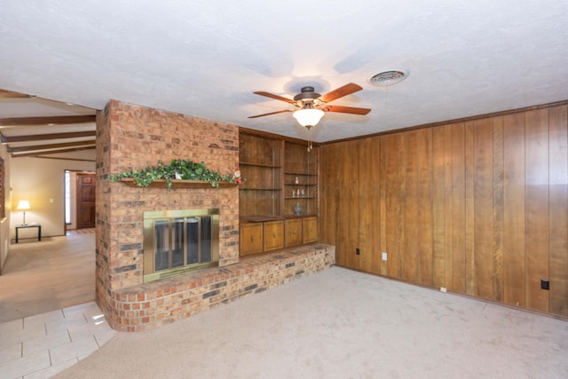 5614 Tranquil Cir, Amarillo, TX 79109 - unfurnished living room with a ceiling fan, a fireplace, light colored carpet, and wooden walls