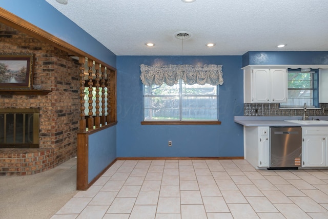 5614 Tranquil Cir, Amarillo, TX 79109 - kitchen with stainless steel dishwasher, a textured ceiling, healthy amount of natural light, white cabinetry, and recessed lighting