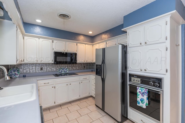 5614 Tranquil Cir, Amarillo, TX 79109 - kitchen featuring black appliances, white cabinetry, backsplash, light tile patterned floors, and light countertops