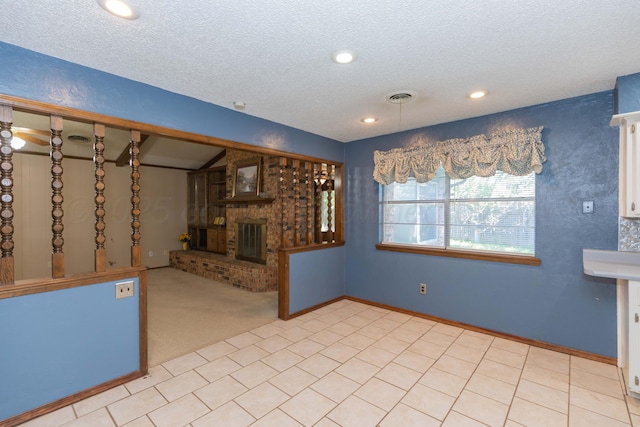 5614 Tranquil Cir, Amarillo, TX 79109 - unfurnished living room with a fireplace, a textured ceiling, recessed lighting, and light colored carpet