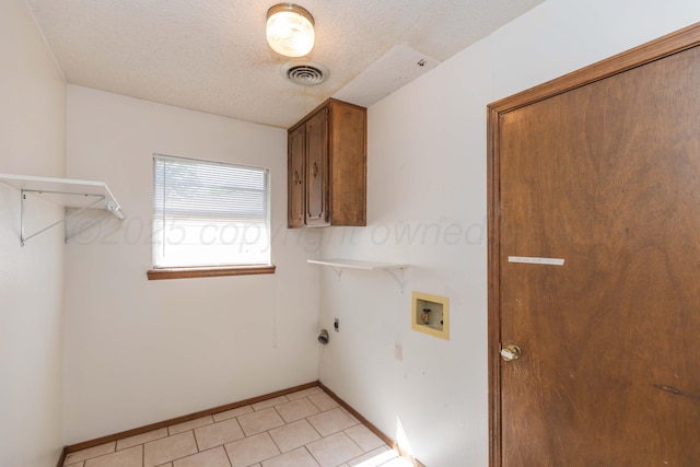 5614 Tranquil Cir, Amarillo, TX 79109 - laundry area featuring cabinet space, hookup for a washing machine, a textured ceiling, light tile patterned floors, and hookup for a gas dryer