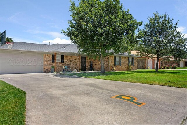 2428 N Fir St, Pampa, TX 79065 - ranch-style home with a front yard, brick siding, an attached garage, and concrete driveway
