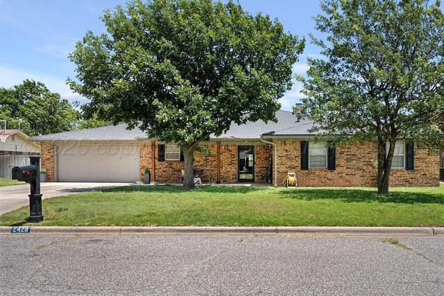 2428 N Fir St, Pampa, TX 79065 - view of front of house with a garage, a front yard, concrete driveway, and brick siding