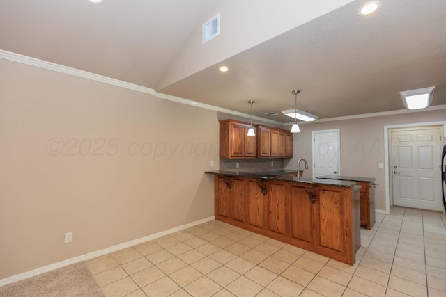 6703 Mosley St, Amarillo, TX 79119 - kitchen with brown cabinetry, a peninsula, a breakfast bar, recessed lighting, and baseboards