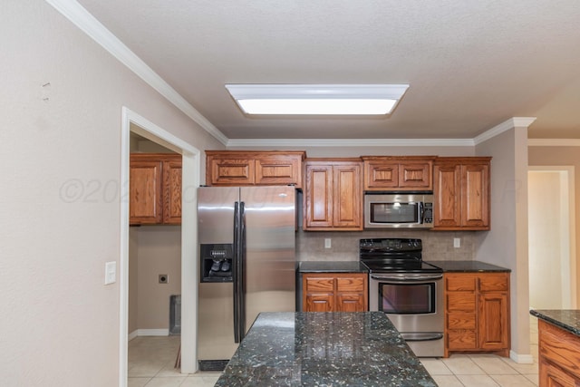 6703 Mosley St, Amarillo, TX 79119 - kitchen with stainless steel appliances, brown cabinets, dark stone countertops, crown molding, and light tile patterned floors