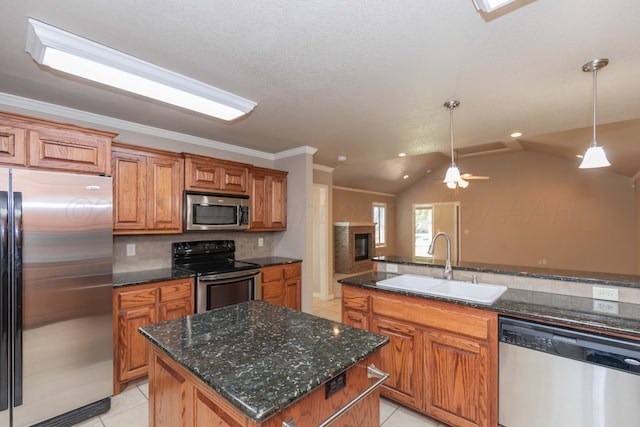 6703 Mosley St, Amarillo, TX 79119 - kitchen with appliances with stainless steel finishes, a sink, light tile patterned floors, brown cabinetry, and decorative light fixtures