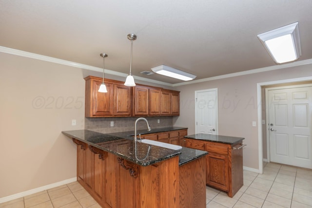 6703 Mosley St, Amarillo, TX 79119 - kitchen featuring brown cabinets, a peninsula, a sink, light tile patterned flooring, and baseboards