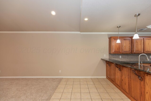 6703 Mosley St, Amarillo, TX 79119 - kitchen with brown cabinets, backsplash, crown molding, baseboards, and dark stone countertops