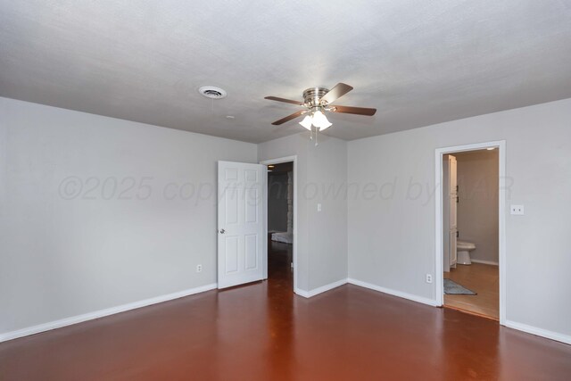 empty room with baseboards, visible vents, concrete floors, and ceiling fan