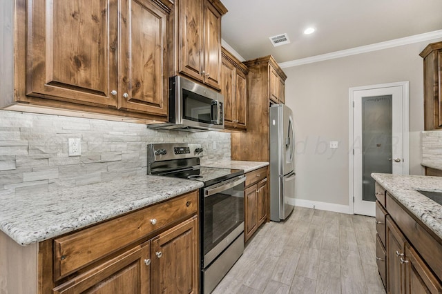 7611 Crestline Dr, Amarillo, TX 79119 - kitchen featuring appliances with stainless steel finishes, crown molding, backsplash, light stone counters, and light wood-type flooring