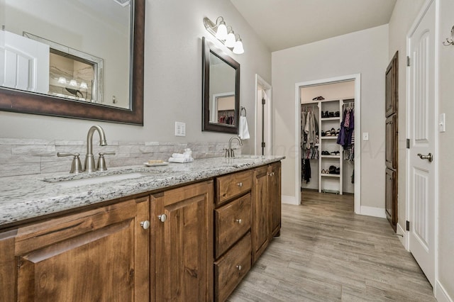7611 Crestline Dr, Amarillo, TX 79119 - full bathroom featuring double vanity, wood finished floors, and a walk in closet