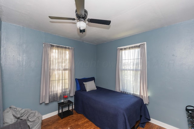 bedroom featuring wood finished floors, baseboards, and a ceiling fan