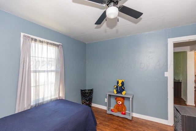 bedroom with ceiling fan, baseboards, and wood finished floors