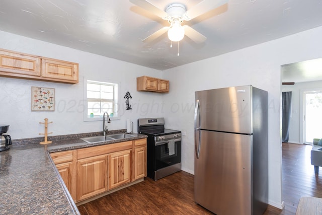 kitchen featuring a sink, appliances with stainless steel finishes, dark countertops, and a healthy amount of sunlight