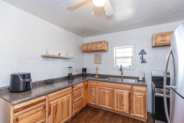 kitchen with ceiling fan, dark stone countertops, appliances with stainless steel finishes, a sink, and dark wood-style floors