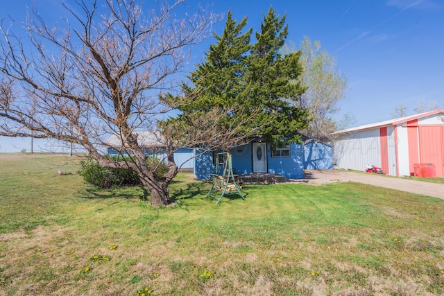 exterior space with an outbuilding, driveway, and a front yard