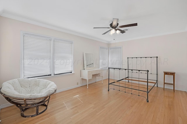 bedroom featuring light wood finished floors, a desk, ornamental molding, baseboards, and ceiling fan