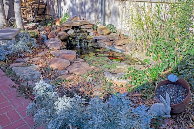 exterior details with a garden pond