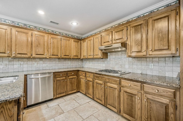 7502 Tripp Ave, Amarillo, TX 79121 - kitchen featuring appliances with stainless steel finishes, under cabinet range hood, brown cabinetry, tasteful backsplash, and ornamental molding
