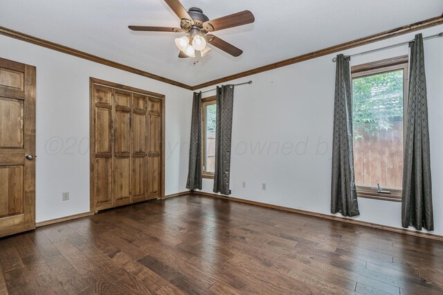 7502 Tripp Ave, Amarillo, TX 79121 - unfurnished bedroom featuring multiple windows, dark wood-style floors, ornamental molding, a closet, and a ceiling fan