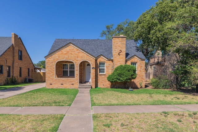 3002 S Polk St, Amarillo, TX 79109 - english style home with brick siding, a shingled roof, a front lawn, a chimney, and central AC unit