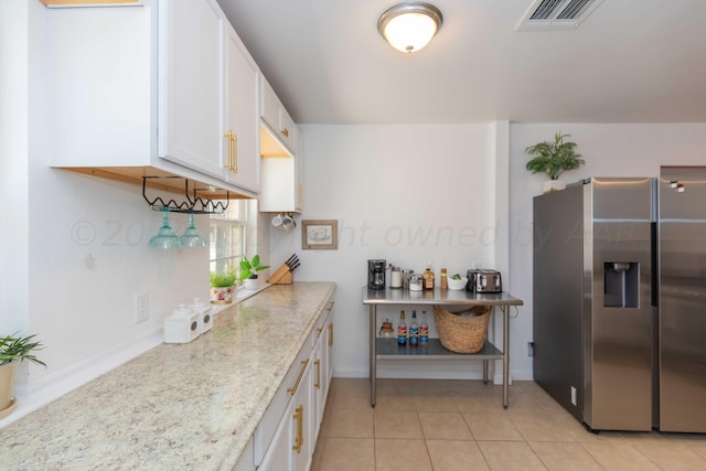 3002 S Polk St, Amarillo, TX 79109 - kitchen with stainless steel fridge with ice dispenser, white cabinetry, baseboards, and light tile patterned floors