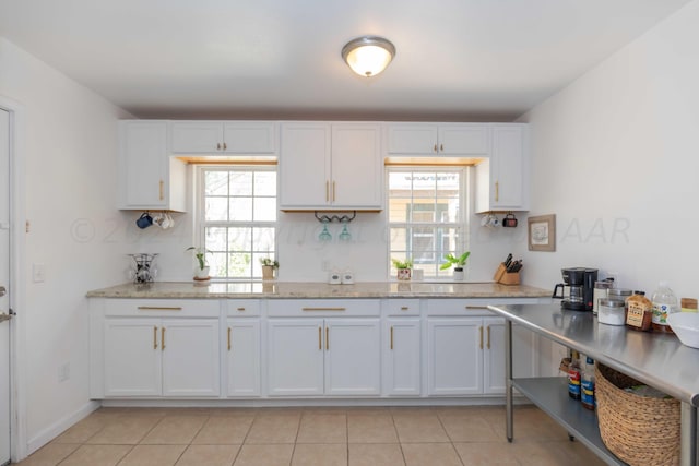 3002 S Polk St, Amarillo, TX 79109 - kitchen featuring healthy amount of natural light, white cabinets, light tile patterned floors, and light stone counters