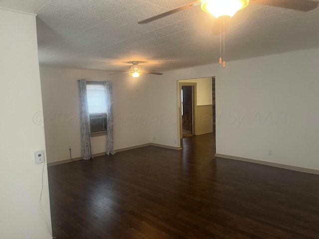 empty room with ceiling fan, baseboards, and dark wood-type flooring