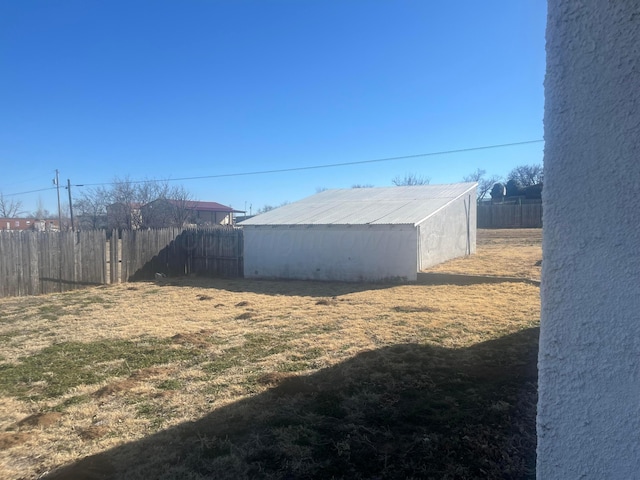 view of yard with fence and an outdoor structure