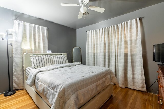 bedroom featuring wood finished floors, lofted ceiling, and ceiling fan
